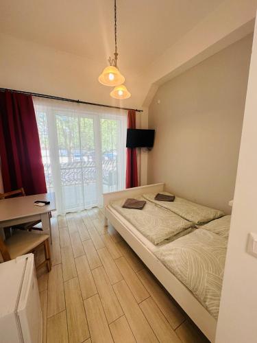 a bedroom with a bed and a desk and a window at Pater Apartments and Rooms in Siófok