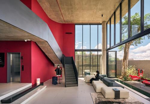 a person sitting on a couch in a room with red walls at Mevan Hotel Dalat in Da Lat