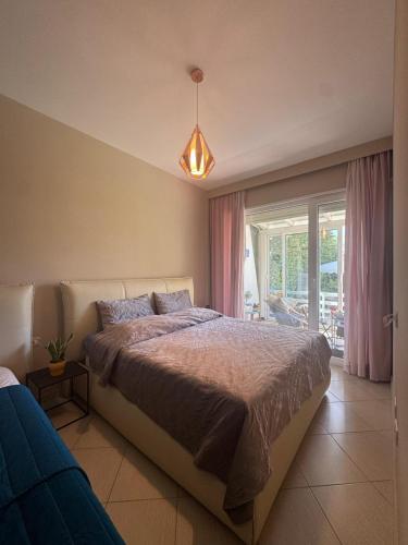 a bedroom with a large bed and a pendant light at Blue Paradise - Gjiri i Lalezit in Lalzit Bay