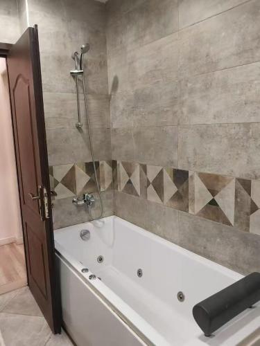 a bath tub in a bathroom with a shower at SUNSKY Apartment Hotel in New cairo