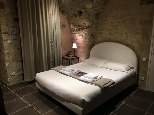 um quarto com uma cama branca num quarto em Rocaminori Hôtel em Louresse-Rochemenier