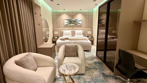 a bedroom with a bed and a chair and a mirror at فندق ايلانا بلس in Farasan