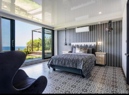 a bedroom with a bed and a view of the ocean at Flamenco@Colwyn in Sheffield Beach