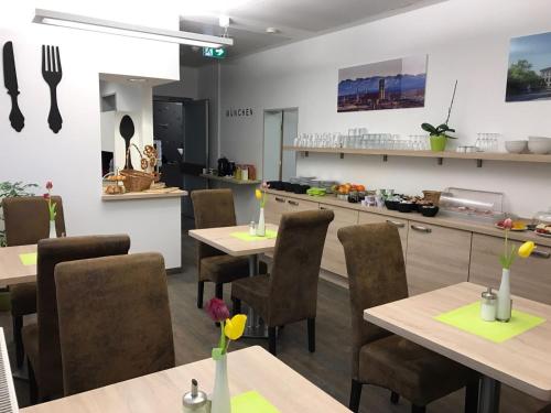 a restaurant with tables and chairs and a kitchen at CREO Munich City in Munich