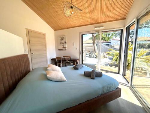a bedroom with a bed with pillows and a large window at Villa et Spa in Pornic