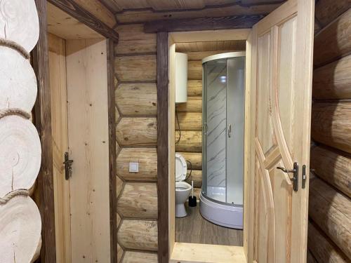 a bathroom in a log cabin with a toilet at Шепіт річки in Synevyr