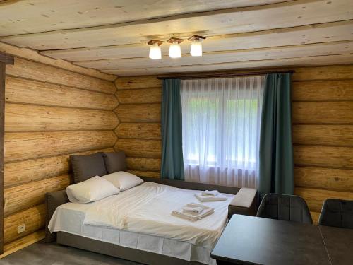 a bedroom with a bed and a table with chairs at Шепіт річки in Synevyr