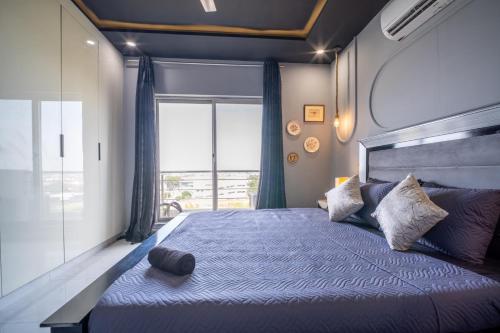 a bedroom with a large bed with a large window at Modern executive stay in Lahore Long stay ready in Lahore
