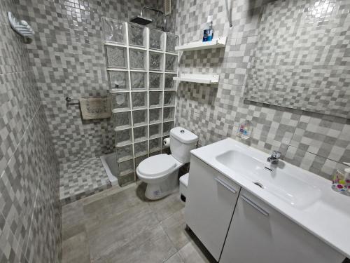 a bathroom with a white toilet and a sink at Tranquilo y céntrico en Chipiona in Chipiona