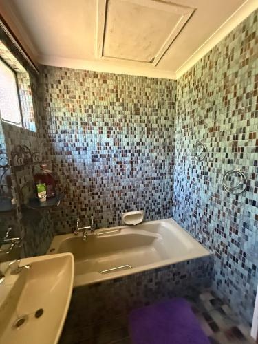 a bathroom with a tub and a sink at Sunrise and sunsets lodge previously known as leopard lodge in Kariba