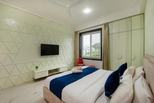a bedroom with a large bed and a flat screen tv at Sunset view Villa 966o9o1oo6 Luxury 5BHK Villa with pool in Nathdwara 2km from temple only By SK in Nāthdwāra