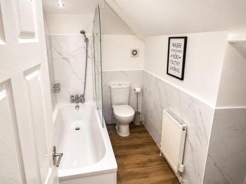 a bathroom with a toilet and a bath tub at Cartref in Caerphilly