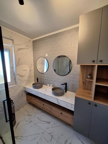a bathroom with two sinks and two mirrors at Villa Rosa - Luxury Apartments in Vrsi