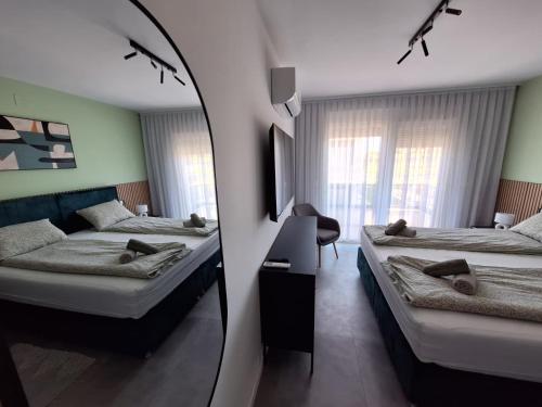 a bedroom with two beds and a mirror at Villa Rosa - Luxury Apartments in Vrsi