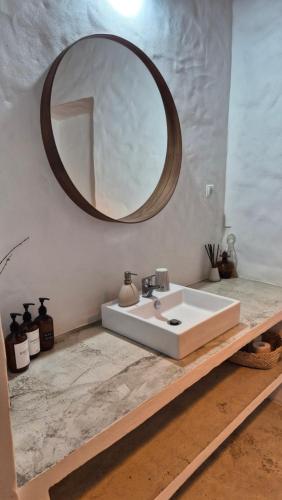 a bathroom with a sink and a mirror on a counter at Papoila in Grândola