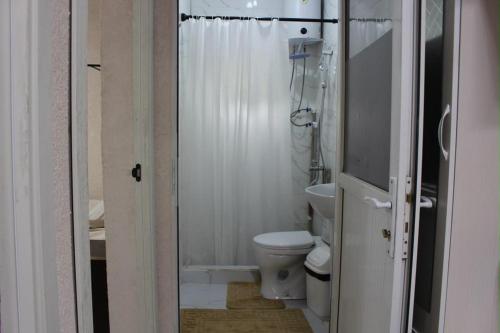 a white bathroom with a toilet and a shower at Sarytam in Bosteri
