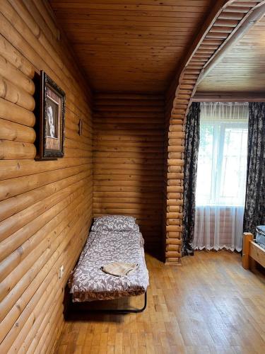 a bedroom with a bed in a wooden room at Котедж "Під Крилом" in Dilyatyn