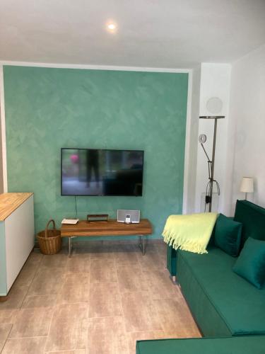 a living room with a couch and a flat screen tv at Ferienhaus Riemanns Refugium in Eutin