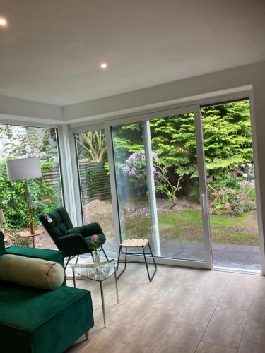 a living room with a green couch and a chair at Ferienhaus Riemanns Refugium in Eutin