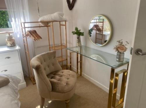 a bedroom with a desk and a chair and a mirror at 27 Cae Du in Abersoch