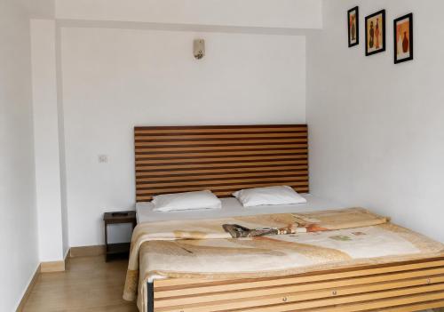 a bedroom with a large bed with a wooden headboard at Hotel Bharmour View in Brāhmaur