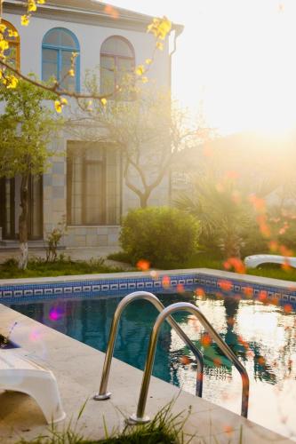 a swimming pool in front of a house at Villa Verde w Warm Pool, BBQ, Concierge in Baku