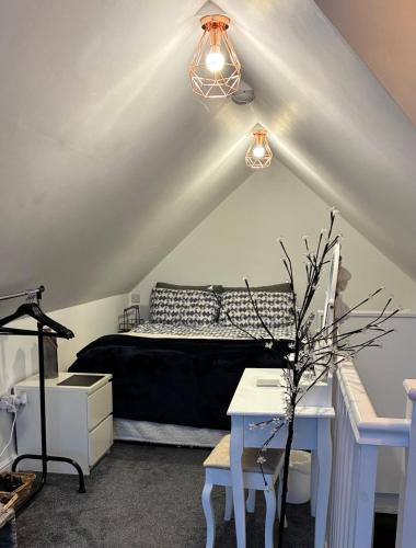 a bedroom with a bed and a desk and a lamp at The Hideaway-Sharples-Bolton in Bolton