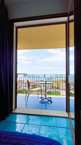 a room with a view of the ocean from a balcony at Hotel Bellavista S'Archittu in S'archittu Cuglieri