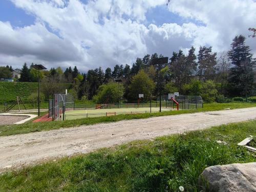 a dirt road with a tennis court in a park at Le Nid de Formiguères in Formiguères