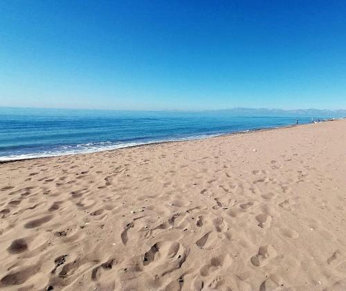 ein Strand mit Fußabdrücken im Sand und dem Meer in der Unterkunft Efe Tiny House in Serik