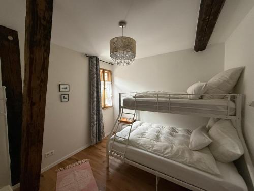 a bedroom with two bunk beds and a chandelier at Wohnen im Denkmal in Weilrod