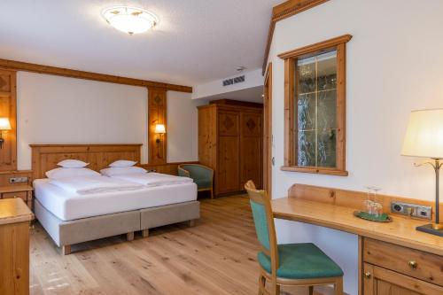 a bedroom with a bed and a desk and a table at Landhaus Grünau in Wals