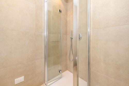a shower with a glass door in a bathroom at Petit Hotel in Caorle
