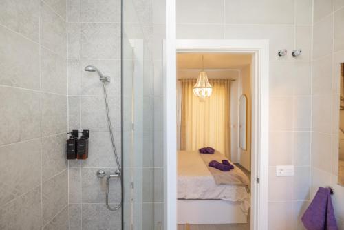 a bathroom with a shower and a bed at Casa flor del Rocio in La Rinconada