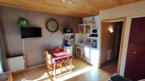 a living room with a table and a refrigerator at Solarium Mountain Studio 4 People Les Angles in Les Angles