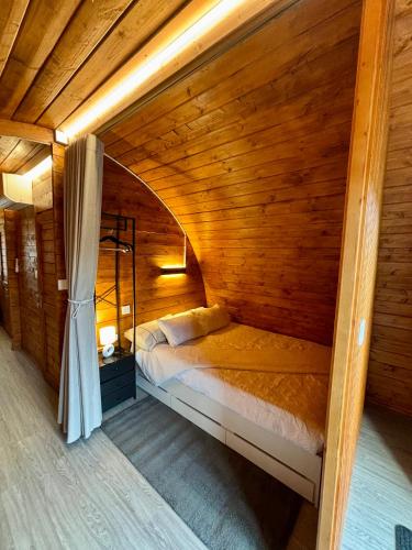a bedroom with a bed in a wooden room at Bungalow de Quintas in Marco de Canaveses