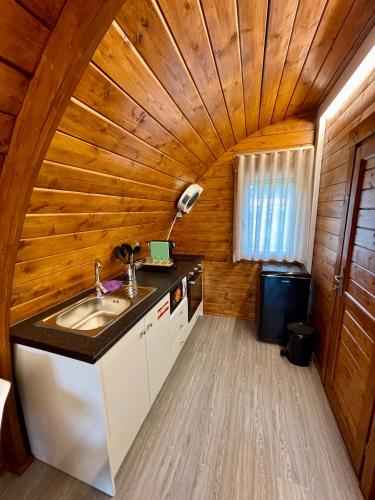 a kitchen with a sink and a wooden ceiling at Bungalow de Quintas in Marco de Canaveses