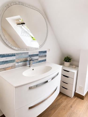a bathroom with a white sink and a mirror at Pavillon des Chouettes in Brech