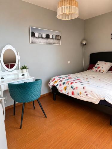 a bedroom with a bed and a desk and a chair at Pavillon des Chouettes in Brech
