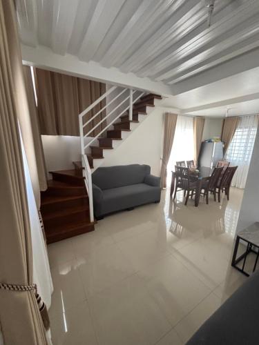 a living room with a couch and a staircase at Arellano Residence in Batangas City
