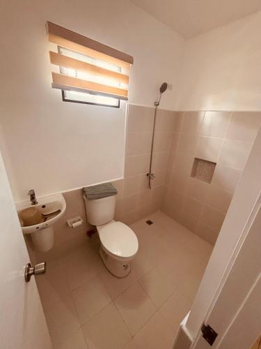 a bathroom with a toilet and a sink at Arellano Residence in Batangas City
