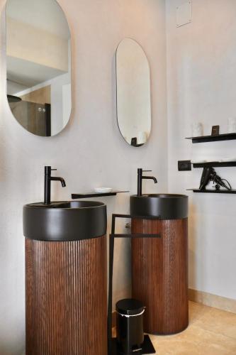 a bathroom with two sinks and a mirror at Taga Suites in Catania