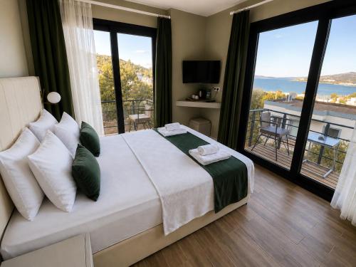 a bedroom with a large bed and a balcony at Bodrum Blue Bay Hotel & Restaurant in Bodrum City