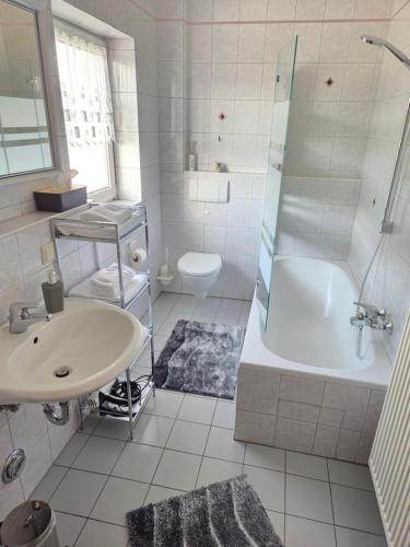 a bathroom with a sink and a tub and a toilet at Ferienhaus Maria in Breitengüßbach