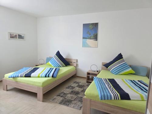 two beds in a room with green and blue at Ferienhaus Maria in Breitengüßbach