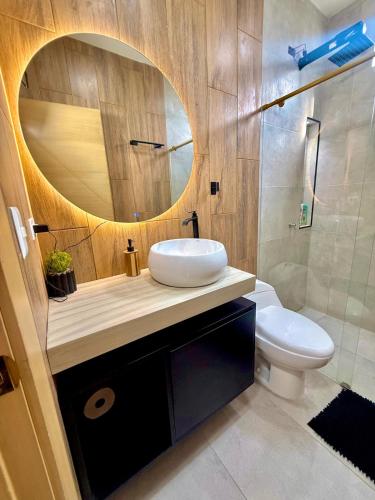 a bathroom with a sink and a mirror and a toilet at Quinta Samalu in Villavicencio