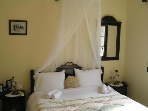 a bedroom with a bed with white sheets and pillows at Fissi Villas agritourism accommodation near the sea in Agios Nikolaos