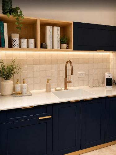 a kitchen with blue cabinets and a sink at Atelier Luma in Zikhron Ya'akov