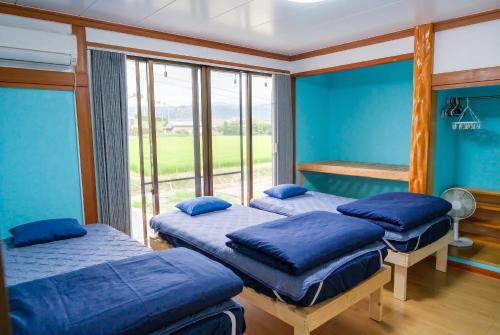 two beds in a room with a window at UMICHIKA AOSHIMA - Private house 一棟貸し in Miyazaki