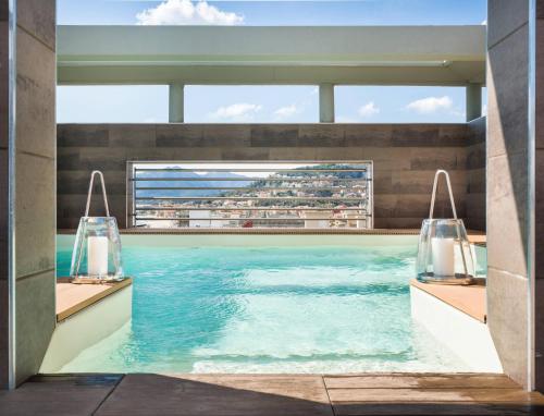a swimming pool in a building with a view of the ocean at Grand Hotel Pietra Ligure in Pietra Ligure